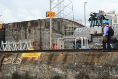 Canal-worker-carrying-line-past-mechanical-line-carrier